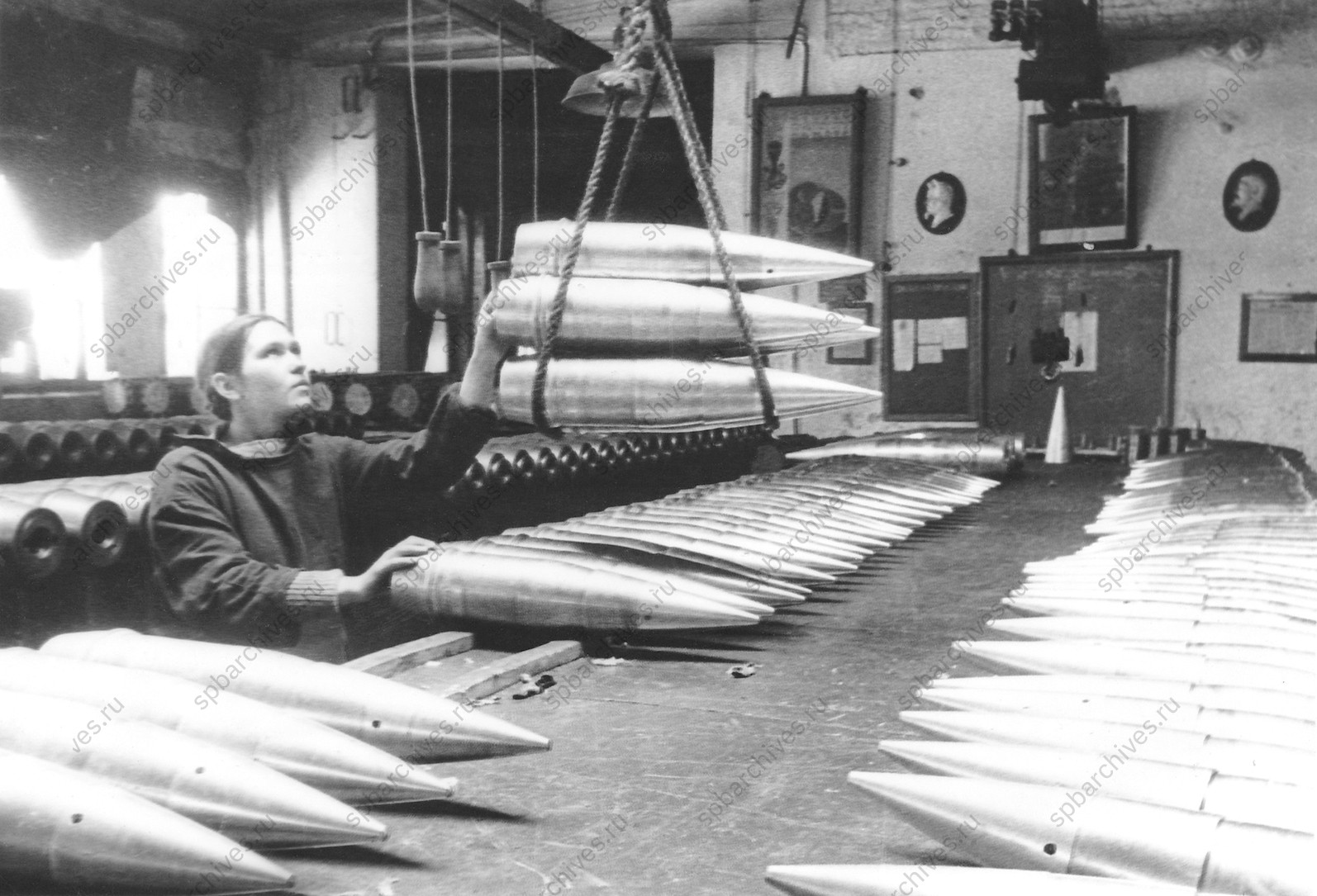 Работница Н-ского завода укладывает снаряды, изготовленные для фронта.<br />
Ленинград. 1943 г.<br />
Автор съёмки: Д.М.Трахтенберг.<br />
<em>ЦГАКФФД СПб. Ар99464.</em>